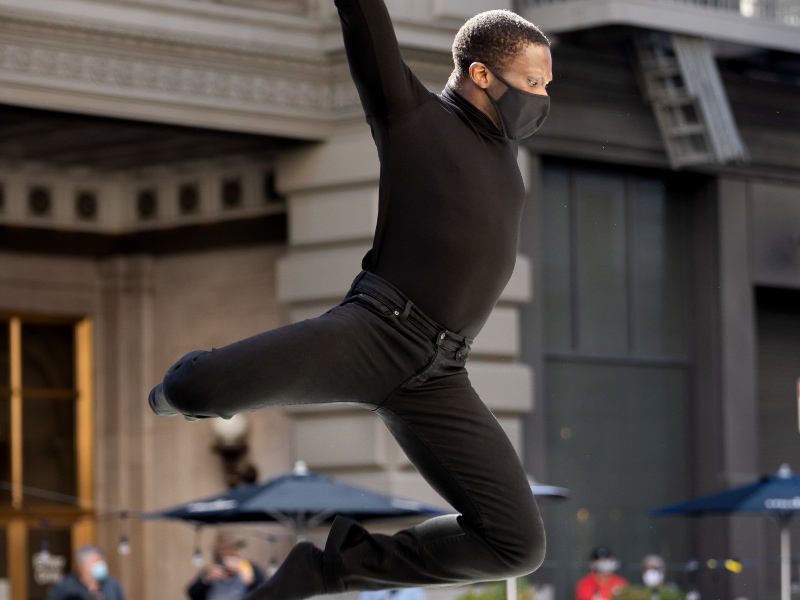 Brandon Alexander hovering in the air while performing onstage in front of John's Grill, photo by Chris Hardy