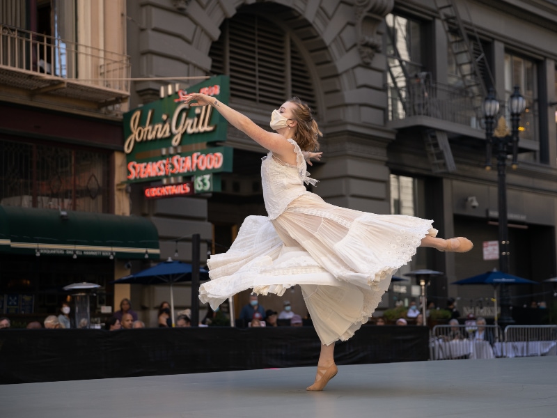 Cassidy Isaacson performing onstage in front of John's Grill in a flowing white dress, photo by Chris Hardy