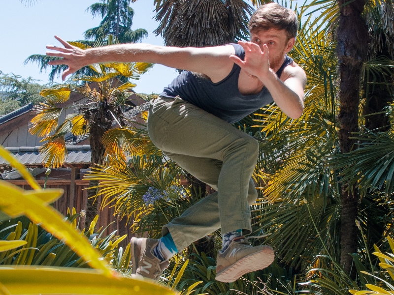 Ian jumping funky in a garden. Photo by Maggie Carey