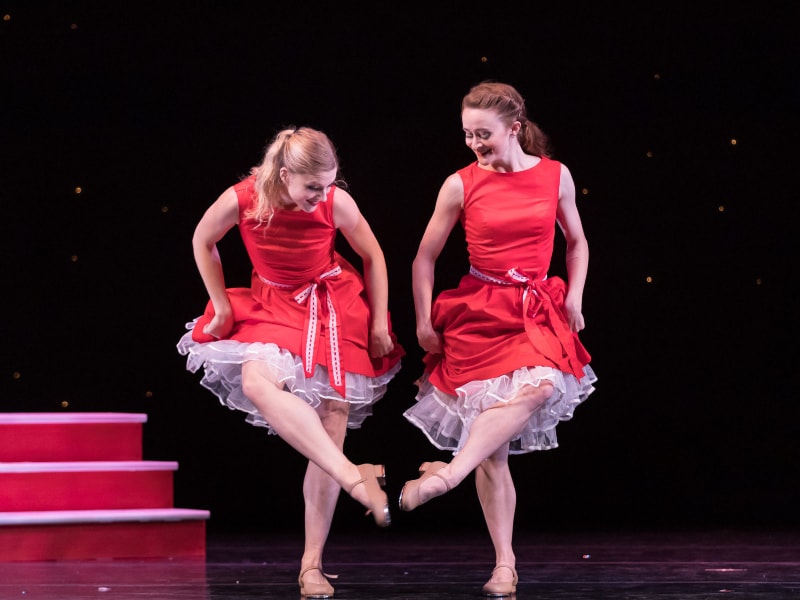 Maggie and Tessa clicking tap shoes together.