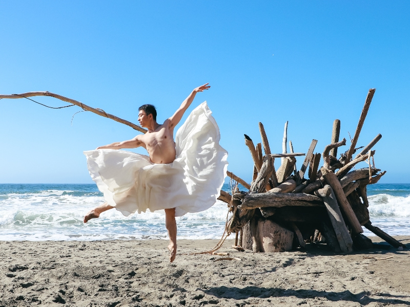 Meng dancing on the beach with a white dress on.